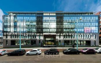 Zakelijk kantoorpand aan de Teleportboulevard 120 in Amsterdam Sloterdijk, met moderne gevel en grote glazen ramen. Ideale locatie voor kantoorruimte huren, met parkeergelegenheid aan de voorzijde.