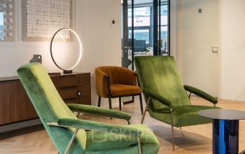 Interieur van kantoorpand op Teleportboulevard 120, Amsterdam Sloterdijk, met moderne, comfortabele loungestoelen en stijlvolle inrichting.