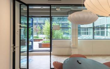 Vergaderruimte in kantoorpand aan Teleportboulevard 120, Amsterdam Sloterdijk, met moderne tafel en stijlvolle stoelen. Grote ramen zorgen voor veel natuurlijk licht.