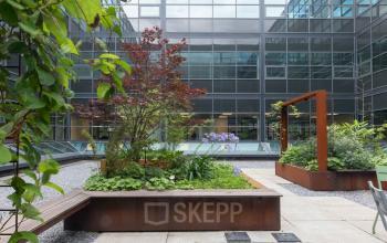 Kantoorpand Teleportboulevard 120 in Amsterdam Sloterdijk, met moderne glazen gevel en groene buitenruimte, ideaal voor kantoorruimte huren.
