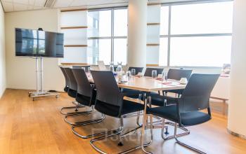 Vergaderruimte in een kantoorpand aan de Radarweg 29, Amsterdam Sloterdijk, voorzien van een lange tafel met stoelen en een scherm, ideaal voor zakelijke besprekingen en voor het huren van kantoorruimte.