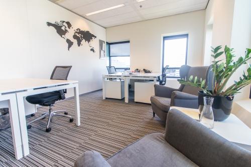 Kantoorruimte huren aan de Radarweg 29 in Amsterdam Sloterdijk met twee werkplekken, stoelen en een wereldkaart aan de muur.