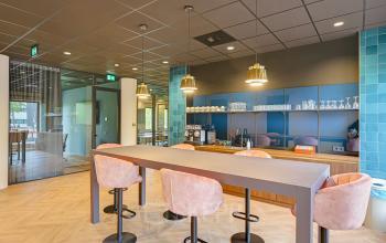 Moderne kantoorpantry met bar en zitplaatsen in kantoorpand aan Kingsfordweg 151, Amsterdam Sloterdijk, ideaal voor een koffiepauze.
