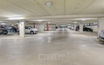 Ondergrondse parkeergarage bij kantoorpand aan Kingsfordweg 151, Amsterdam Sloterdijk, met geparkeerde auto's en duidelijke bewegwijzering.