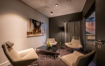 Gezellig ingerichte loungeruimte in een kantoorpand aan de Teleportboulevard 110, Amsterdam Sloterdijk. Deze ruimte is ideaal voor kantoorruimte huren met comfortabele stoelen en modern decor.