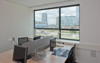 Zicht op een kantoorpand in Amsterdam Sloterdijk met bureau-opstelling en uitzicht op moderne gebouwen, ideaal voor kantoorruimte huren.