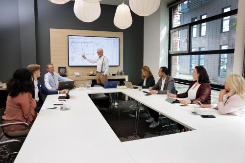 Zakelijke bijeenkomst in kantoor aan Teleportboulevard 110, Amsterdam Sloterdijk. Mensen werken samen in een vergaderzaal met moderne technologie, ideaal voor kantoorruimte huren.