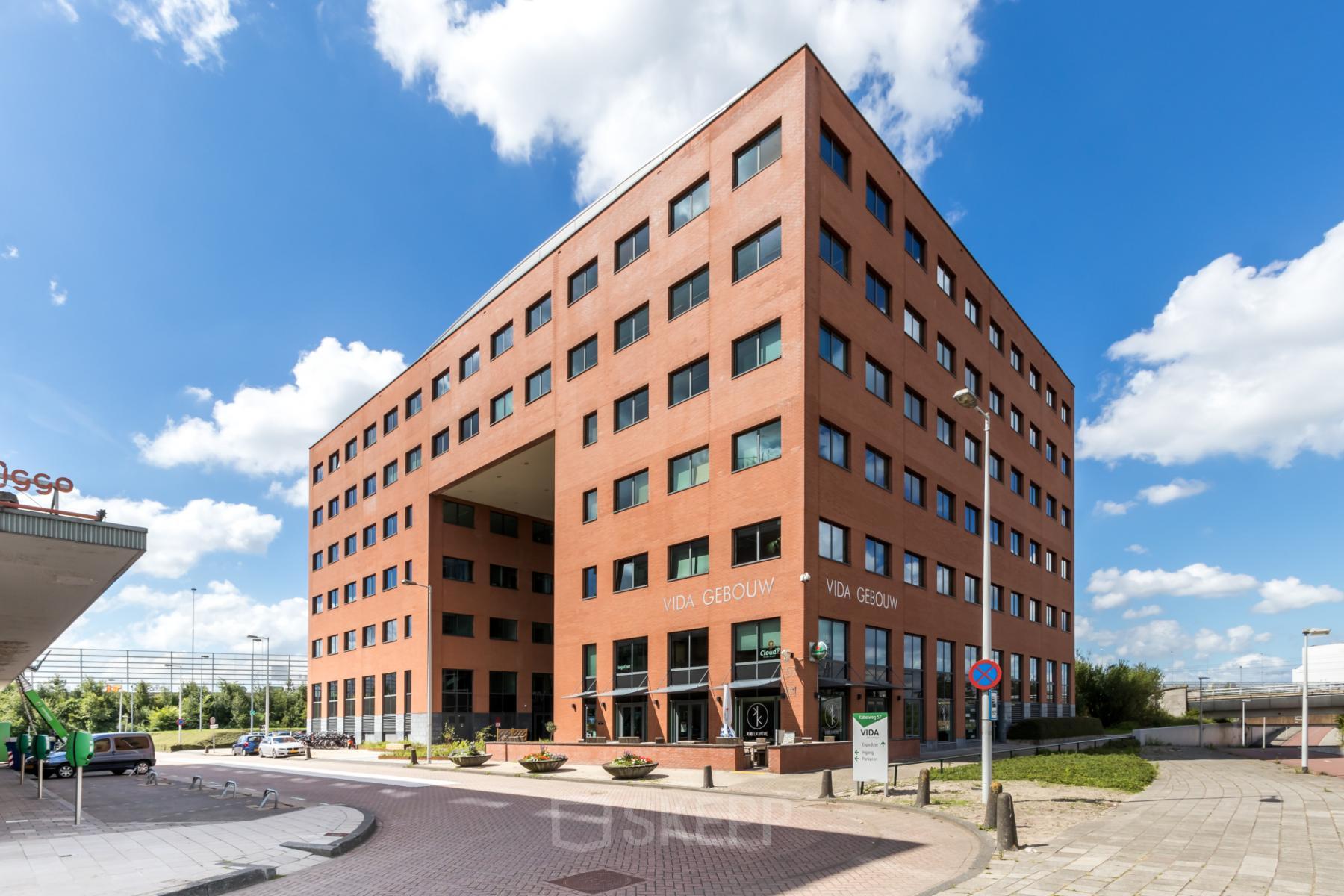 Buitenkant van kantoorpand op Kabelweg 57 in Amsterdam Sloterdijk, met heldere blauwe lucht en moderne architectuur, ideaal voor kantoorruimte huren.