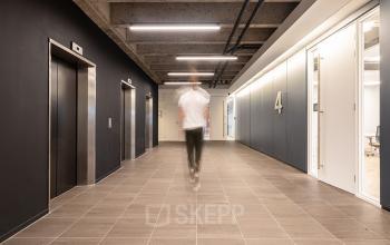 Modern kantoorpand op Kabelweg 37 in Amsterdam Sloterdijk met twee liften en een gang met metalen plafonds, geschikt voor bedrijven die kantoorruimte willen huren. Herkenbare stijl en professioneel ingericht.