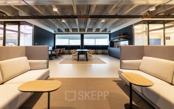 Grote en moderne kantoorruimte huren op Kabelweg 37 in Amsterdam Sloterdijk, voorzien van comfortabele zitplaatsen en lange werktafels onder industrieel plafond.