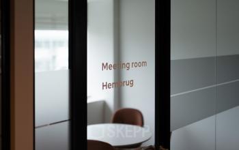 Vergaderkamer in het kantoorpand aan de Kabelweg 37 in Amsterdam Sloterdijk, voorzien van vergadertafel en stoelen. Perfecte plek voor wie kantoorruimte wil huren voor bijeenkomsten in een zakelijke omgeving.