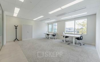 Kantoorruimte huren op Basisweg 32, Amsterdam Sloterdijk met veel natuurlijk licht, twee bureaus en stoelen. Moderne uitstraling.