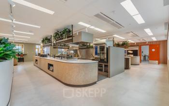 Moderne, lichte kantoorruimte huren op Basisweg 32, Amsterdam Sloterdijk. Ruime, open werkruimte met groene accenten en stijlvolle inrichting.