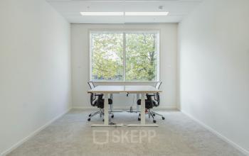 Kantoorruimte huren op Basisweg 32 in Amsterdam Sloterdijk, Amsterdam. Heldere ruimte met bureau en stoelen, minimalistisch ingericht met grote ramen voor veel natuurlijk licht.