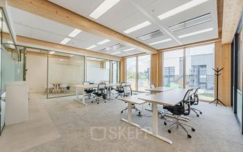 Moderne kantoorruimte huren op Basisweg 32, Amsterdam Sloterdijk, met glaswanden, bureaus en ergonomische stoelen, grote ramen voor natuurlijk licht.