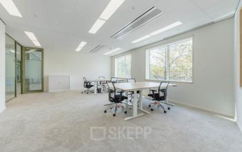 Kantoorruimte huren op Basisweg 32, Amsterdam Sloterdijk met een lichte en open indeling, voorzien van bureaus en stoelen, en grote ramen die veel natuurlijk licht binnenlaten.
