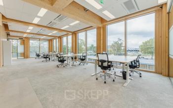 Heldere kantoorruimte op Basisweg 32 in Amsterdam Sloterdijk, met grote ramen en moderne bureaus, perfect voor werkplekantoren. Ideaal voor wie kantoorruimte wil huren in een lichte omgeving.