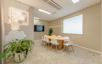 Kantoorpand op Basisweg 32, Amsterdam Sloterdijk met moderne vergaderruimte, inclusief tafel, stoelen en een inspirerende quote aan de muur. Ideaal voor kantoorruimte huren.