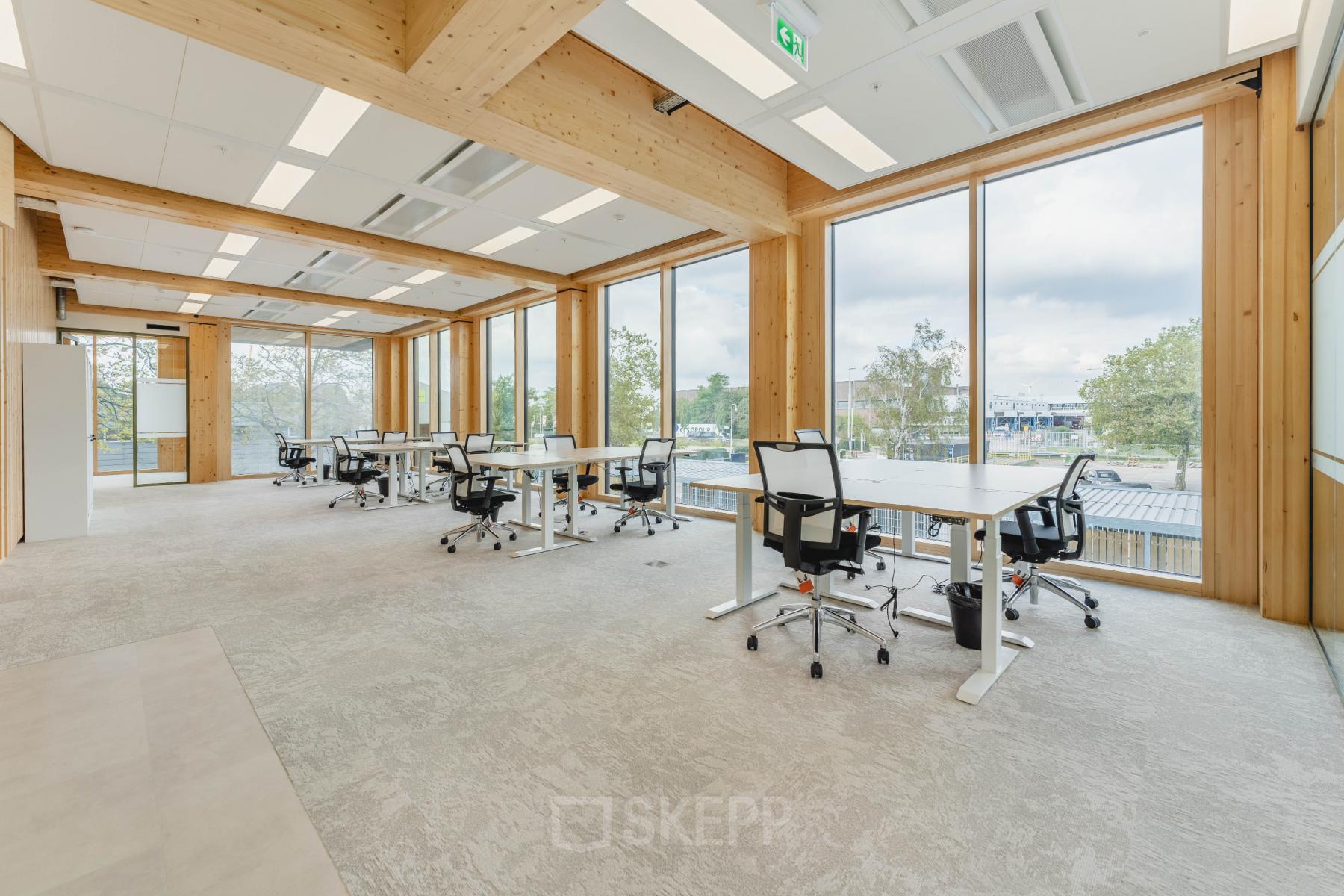 Heldere kantoorruimte op Basisweg 32 in Amsterdam Sloterdijk, met grote ramen en moderne bureaus, perfect voor werkplekantoren. Ideaal voor wie kantoorruimte wil huren in een lichte omgeving.