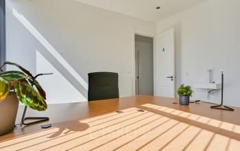 Lichtovergoten kantoorruimte te huur op Tijnmuiden 59, Amsterdam Sloterdijk, met een modern bureau en planten voor een frisse sfeer.