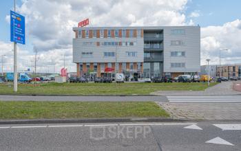 Buitenzijde van het kantoorpand op Tijnmuiden 59 in Amsterdam Sloterdijk, omringd door geparkeerde auto's. De moderne gevel biedt mogelijkheden voor kantoorruimte huren.