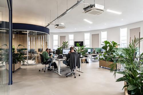 Modern kantoorpand aan Arlandaweg 92, Amsterdam Sloterdijk, met medewerkers aan het werk tussen veel groen en ergonomische werkplekken.