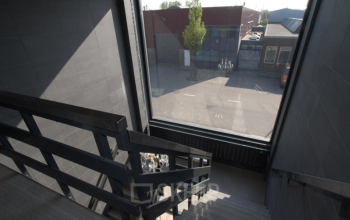 Trap met groot raam in kantoorpand op Elektronstraat 15, Amsterdam Sloterdijk. Ruig, industrieel uitzicht vanuit het kantoor.