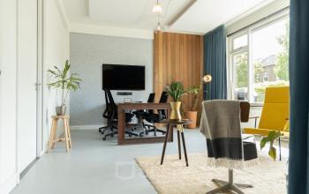 Moderne kantoorruimte op Overtoom 141 in Amsterdam West met strak bureau, comfortabele stoel en gezellige planten.