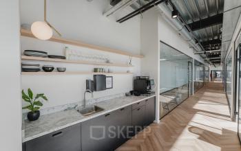 Moderne kantoorruimte huren op Bos en Lommerplein 280, Amsterdam West, met stijlvolle pantry en glazen kantoorwanden.