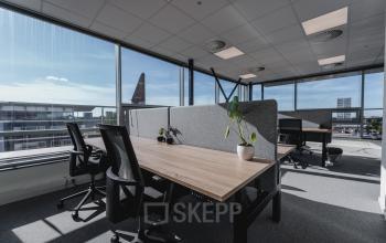 Ruime kantoorruimte op Bos en Lommerplein 280, Amsterdam West. Moderne werkplekken met grote ramen en uitzicht naar buiten. De ruimte is voorzien van bureaus, bureaustoelen en enkele planten voor een frisse werksfeer.