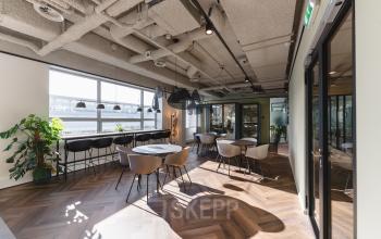 Moderne kantoorruimte met grote ramen, parketvloer en stijlvolle stoelen op Bos en Lommerplein 280, Amsterdam West. Ideaal om kantoorruimte te huren in een inspirerend kantoorpand.