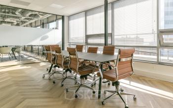 Moderne vergaderruimte binnen kantoorpand aan Bos en Lommerplein 280, Amsterdam West, met grote tafel en comfortabele stoelen.