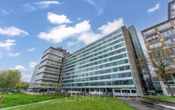 Kantoorpand aan het Bos en Lommerplantsoen 1 in Amsterdam West, met moderne architectuur en groene omgeving, ideaal voor kantoorruimte huren.