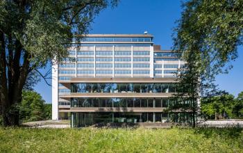 Kantoorpand Nachtwachtlaan 20 in Amsterdam West met moderne architectuur en meerdere verdiepingen omringd door bomen en groen. Ideaal voor kantoorruimte huren.
