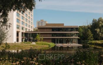Moderne kantoorpand aan de Nachtwachtlaan 20 in Amsterdam West, gelegen aan het water met omliggend groen. Ideaal voor bedrijven die kantoorruimte willen huren met inspirerende uitzicht.