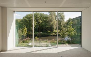 Kantoorruimte met grote ramen die uitzicht bieden op een groene omgeving, ideaal voor bedrijven die kantoorruimte willen huren in Amsterdam West.