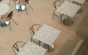 Bovenaanzicht van een gemeubileerde kantoorruimte aan de Nachtwachtlaan 20, Amsterdam West, met tafels en stoelen geschikt voor zakelijke bijeenkomsten of pauzes.