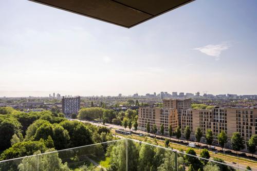 Uitzicht vanaf een balkon op Nachtwachtlaan 20 in Amsterdam West, met een panoramisch uitzicht over de stad en omringende gebouwen.
