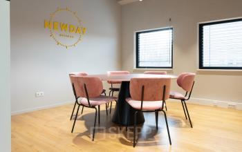 Kantoorruimte huren in Amsterdam Nieuw-West, Amsterdam, gelegen aan Overschiestraat 63, met een vergadertafel en roze stoelen.