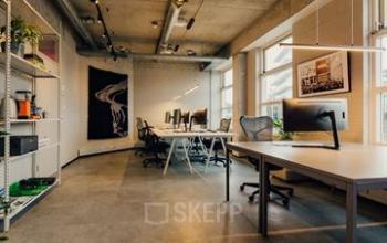 Modern ingerichte kantoorruimte op Rigakade 10, Amsterdam West, met werkplekken en een lichte, industriële uitstraling. De ruimte is uitnodigend voor professionals die kantoor wensen te huren.