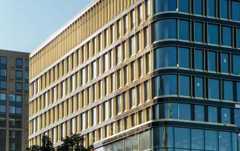 Modern kantoorpand op de hoek van Kon. Wilhelminaplein 4, Amsterdam West, met grote glazen gevels en meerdere verdiepingen, ideaal voor kantoorruimte huren.