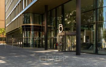 Buitenzijde van modern kantoorpand op Kon. Wilhelminaplein 4, Amsterdam West met glazen gevel en entree. Ideale locatie voor kantoorruimte huren in levendige omgeving.