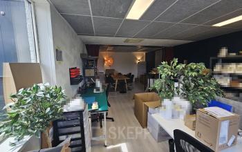 Kantoor te huur aan de Gyroscoopweg 23-25, Amsterdam Westpoort. De ruimte is gemeubileerd met bureau's, stoelen, planten en opbergdozen, geschikt voor werkactiviteiten.