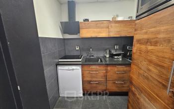 Kantoorpand aan de Gyroscoopweg 23-25 in Amsterdam Westpoort met keukenfaciliteiten zoals een vaatwasser, inductieplaat en houten kasten.