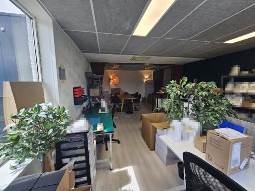 Kantoor te huur aan de Gyroscoopweg 23-25, Amsterdam Westpoort. De ruimte is gemeubileerd met bureau's, stoelen, planten en opbergdozen, geschikt voor werkactiviteiten.