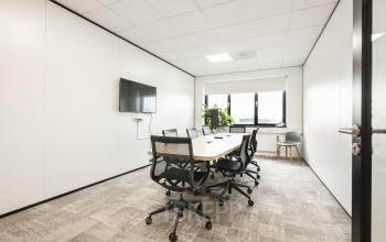 Moderne kantoorruimte te huur op Zekeringstraat 46 in Amsterdam Westpoort, voorzien van een vergadertafel, stoelen en tv-scherm.