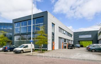 Buitenzijde van het kantoorpand op Poortland 242, Amsterdam Westpoort met parkeerplaatsen voor de deur.