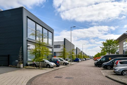 Exterieur van kantoorpand aan Poortland 242 in Amsterdam Westpoort, met parkeergelegenheid voor meerdere auto's langs een rustige straat. Ideaal voor bedrijven die kantoorruimte willen huren.