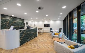 Moderne kantoorlounge op Hullenbergweg 278-308, Amsterdam Zuid-Oost. Zithoek met stoelen en tafels, receptie en wachtruimte voor zakelijke huur.