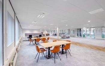 Ruime, lichte kantoorruimte huren op Hullenbergweg 278-308 in Amsterdam Zuid-Oost. Moderne inrichting met bureaus, stoelen, en veel ramen voor natuurlijk licht.